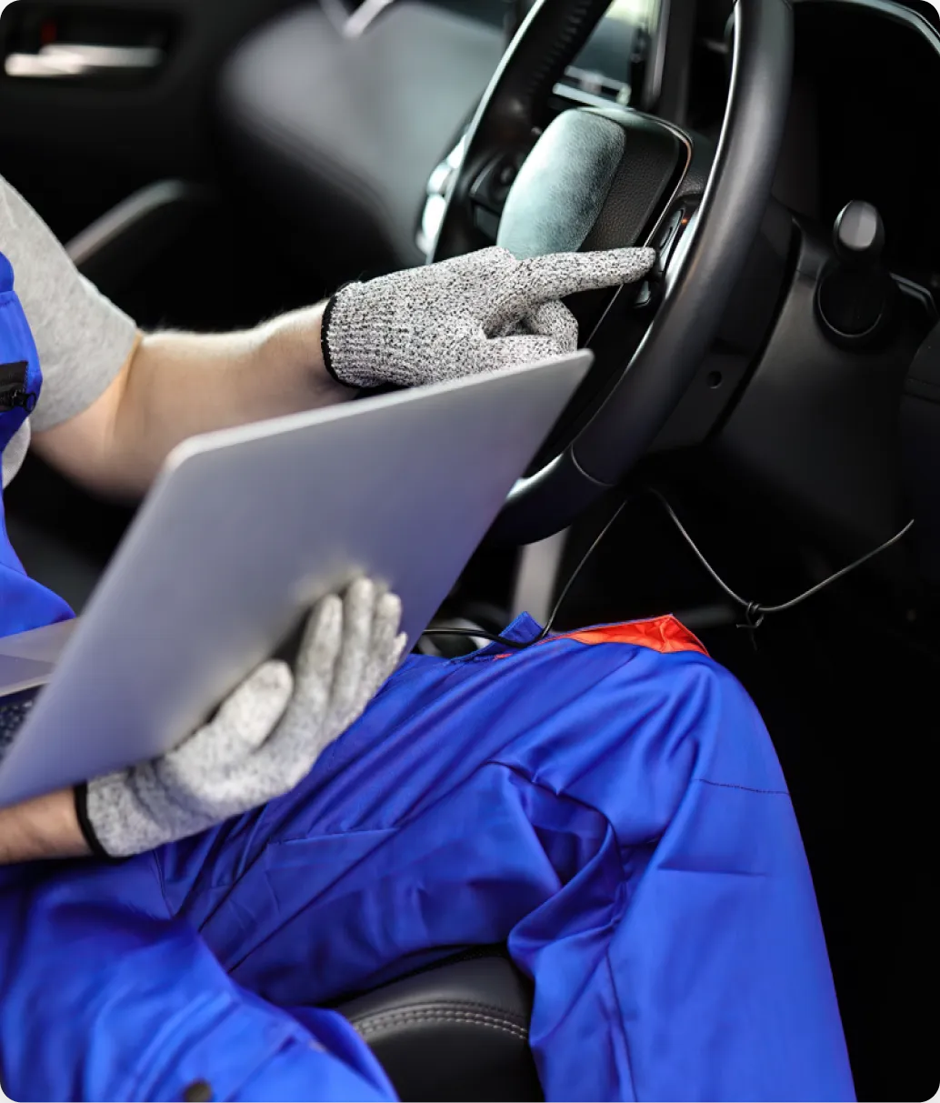 Auto Repair Careers in Ipswich MA at New Meadows Motor Car. Mechanic using laptop in vehicle