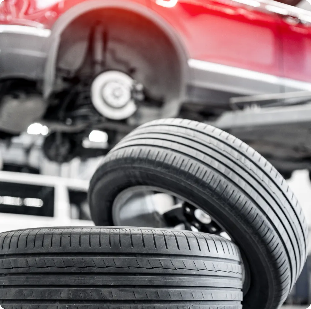 Tire Sales & Services in Ipswich MA At New Meadows Motor Car. Car tires stacked near lifted vehicle