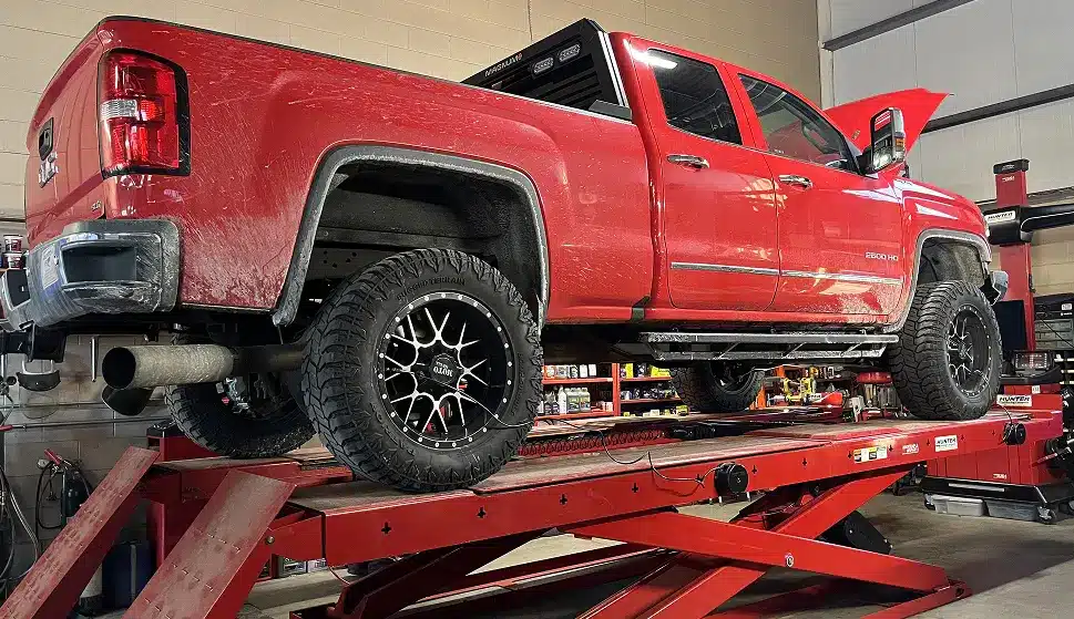 Keep My Car in Ipswich MA At New Meadows Motor Car. Red pickup truck on lift